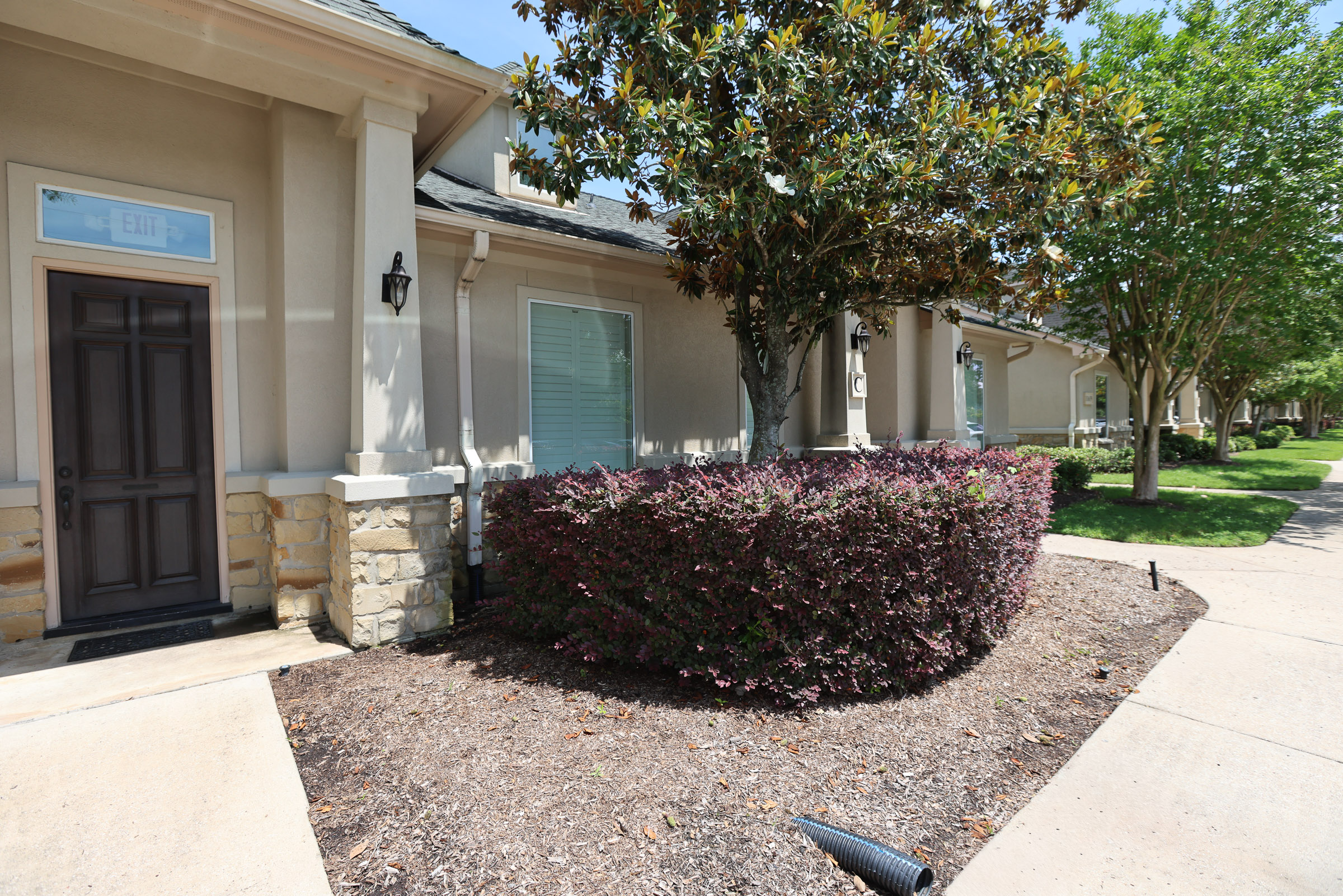 Community entrance landscaping with maintained shrub beds