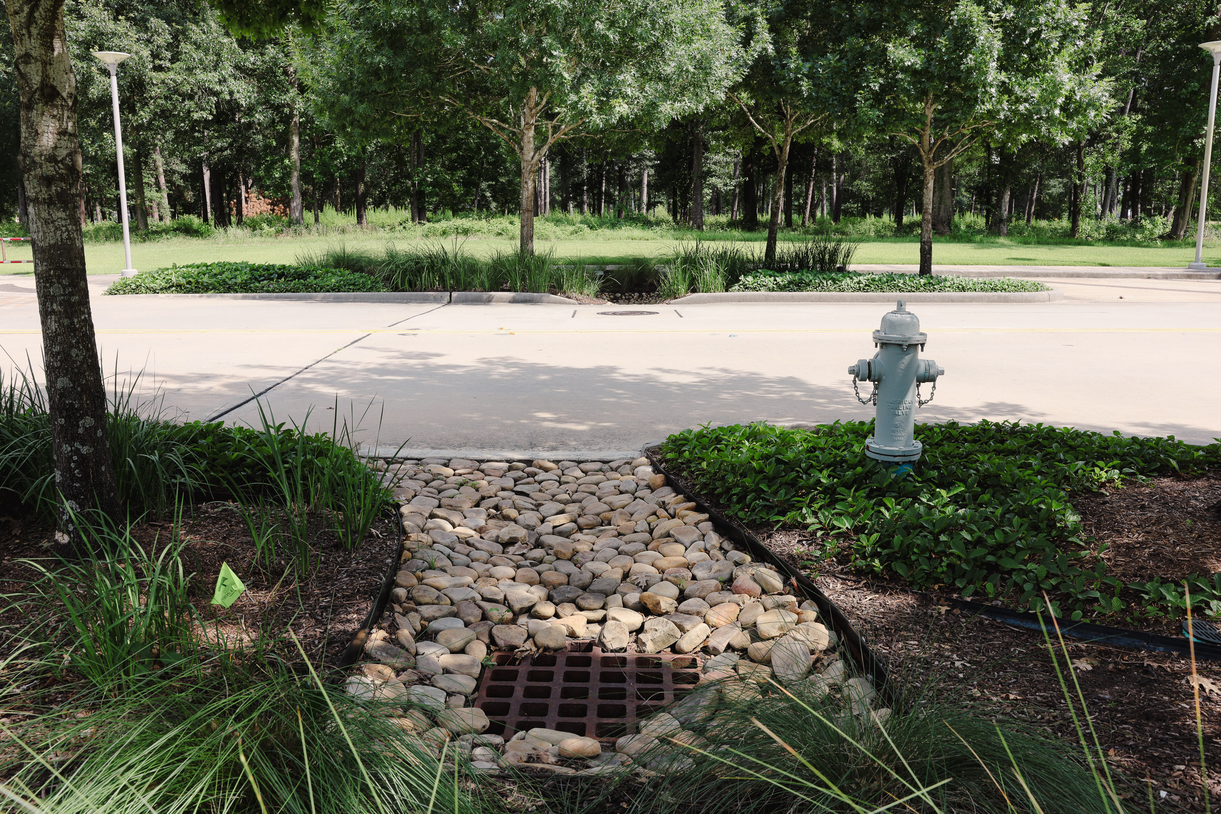 Rock bed drainage area beside a maintained commercial walkway